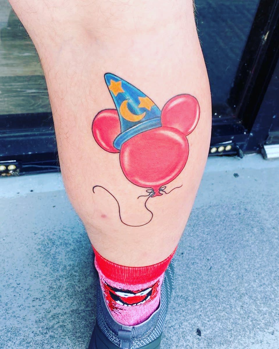 Colorful tattoo of a red Mickey Mouse balloon wearing the Sorcerer's Apprentice hat