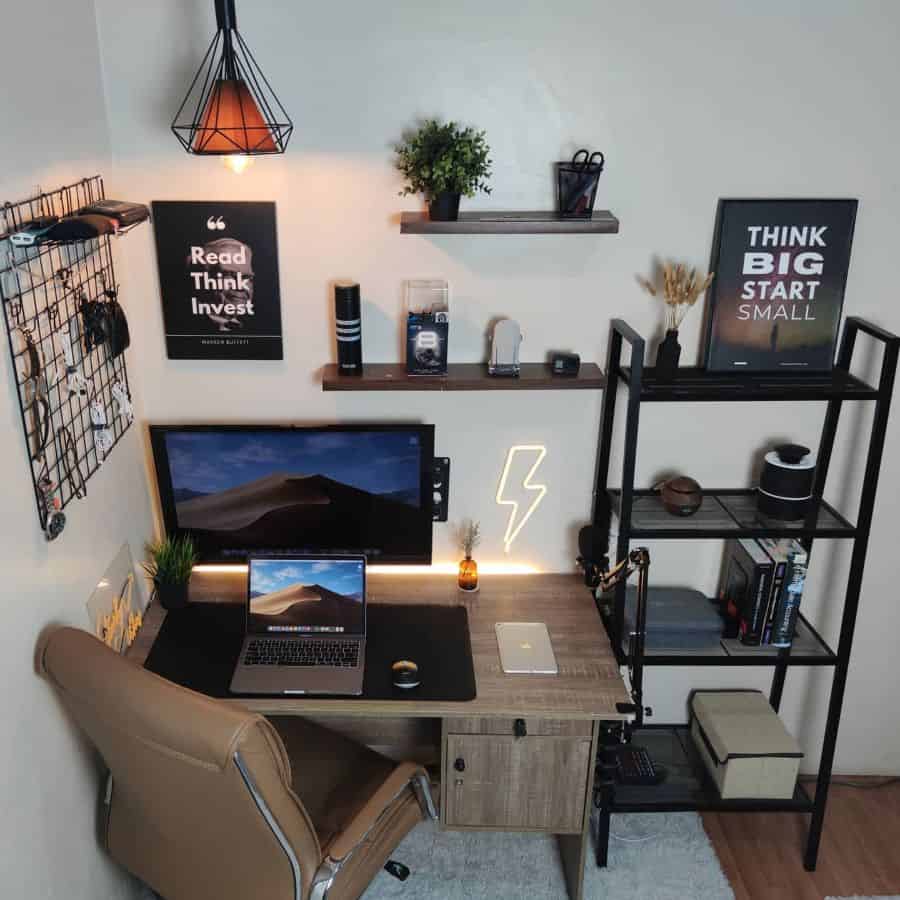 Cozy home office with a laptop, shelves, decor, and motivational posters on the wall