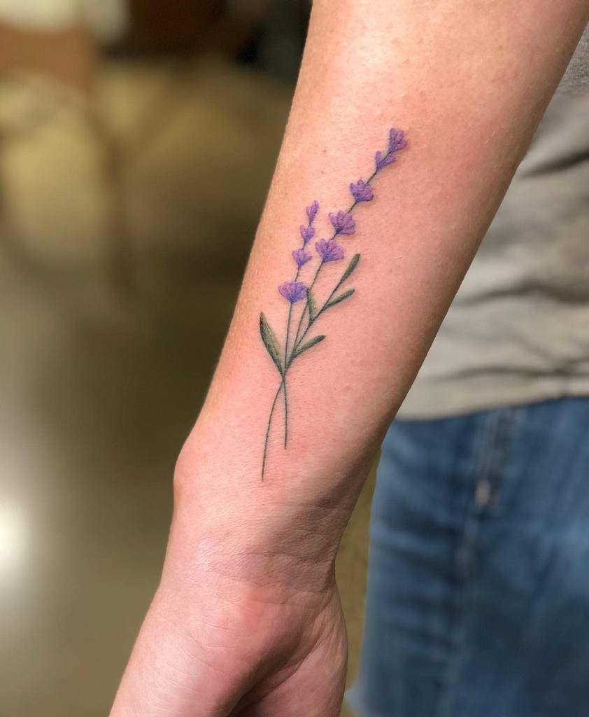 A wrist tattoo of a lavender branch with purple flowers