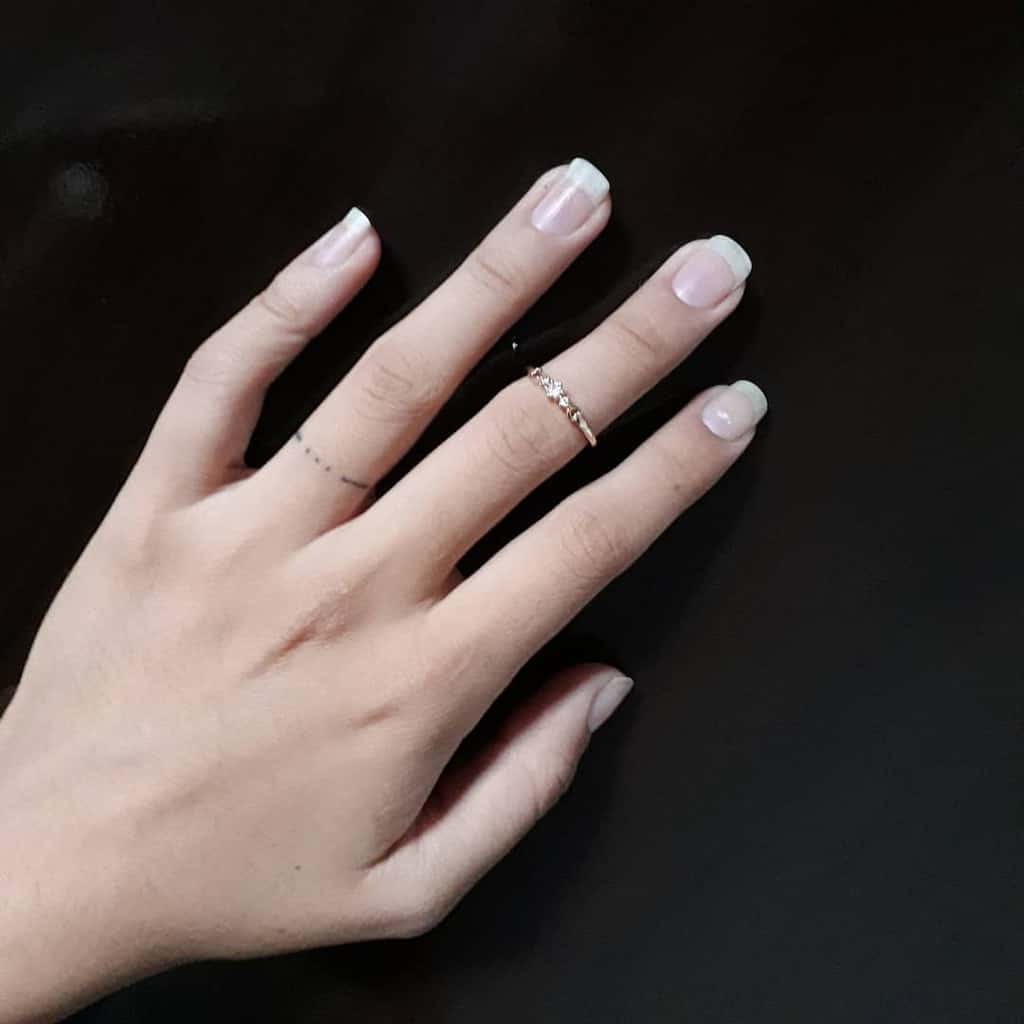 A minimalist ring tattoo with small dots, creating a subtle and delicate design