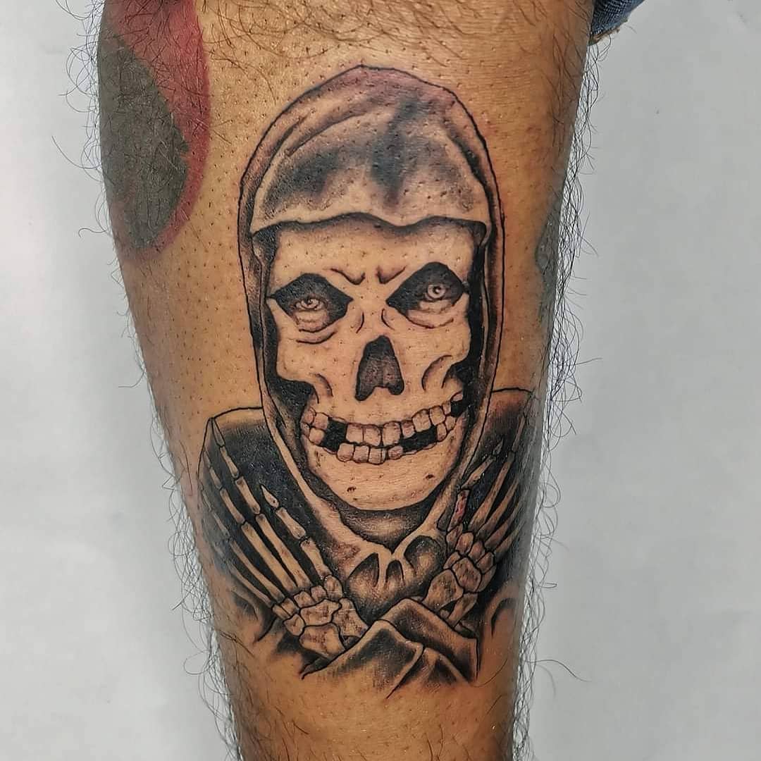 Grim reaper tattoo on a leg, featuring a hooded skeleton