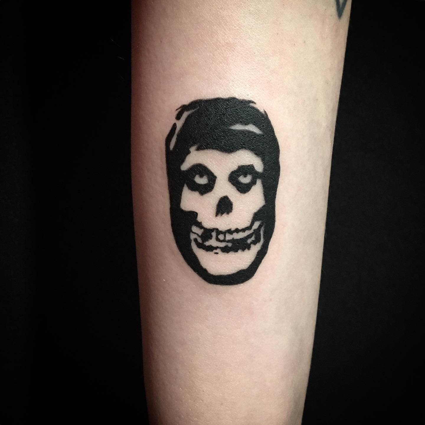 Tattoo of a black skull on a forearm
