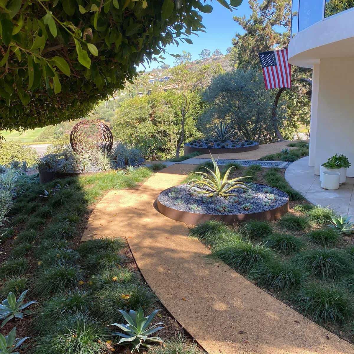 modern front yard dirt path american flag abstract statue 