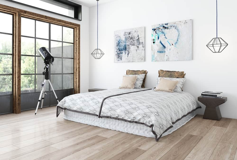 Minimalist bedroom with telescope abstract wall art pendant lighting and large windows.
