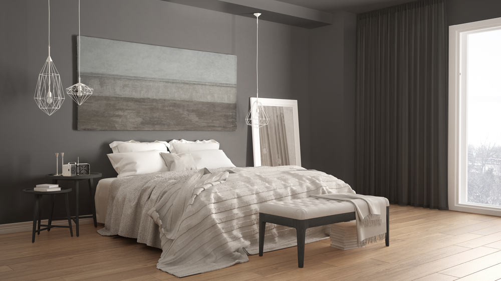 Modern minimalist bedroom with pendant lights gray walls and wood floor.