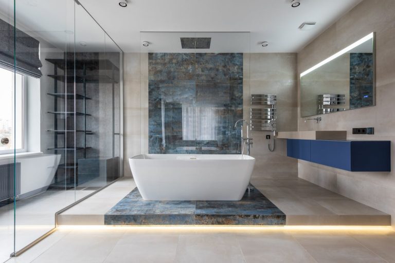 Modern bathroom with a freestanding tub and blue vanity—purposeful improvements that transform daily living