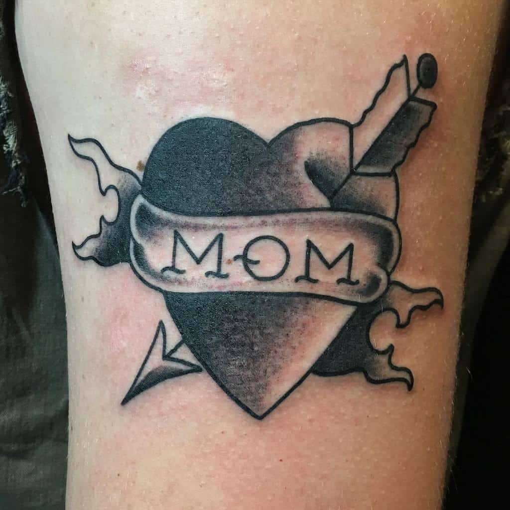 Tattoo of a blazing heart with a "MOM" banner, pierced by a dagger