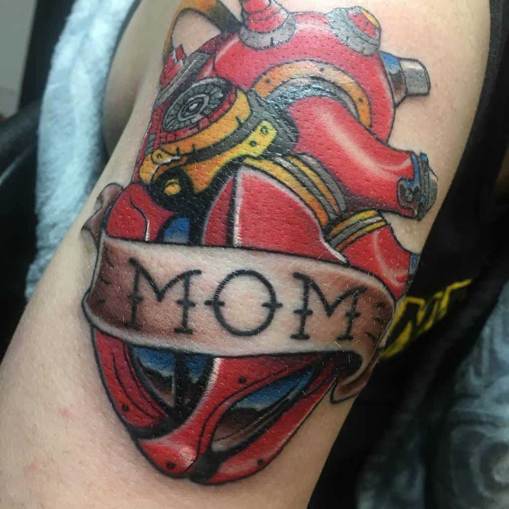 Sure! Here is a description of the tattoo without a dot at the end: Tattoo of a mechanical heart with "MOM" proudly displayed on a banner wrapped around it