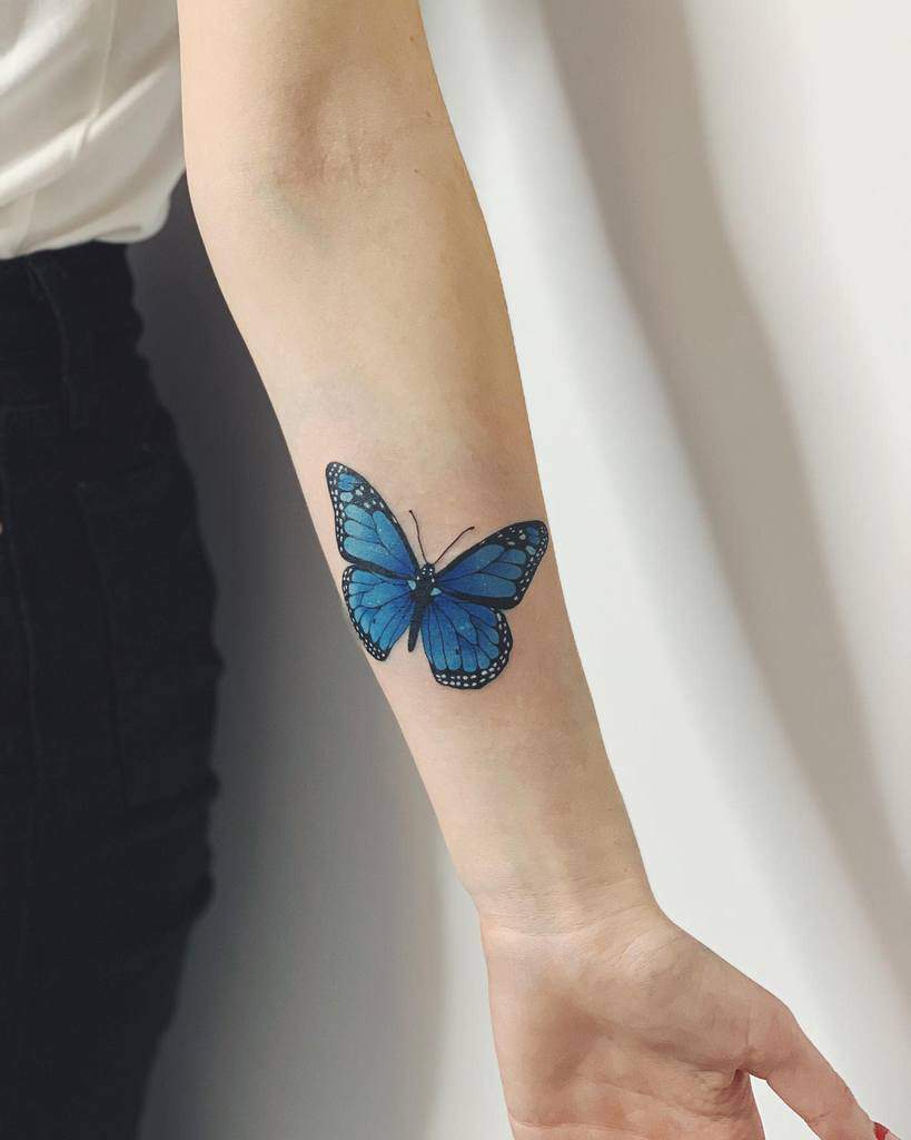 A striking monarch butterfly tattoo on the forearm