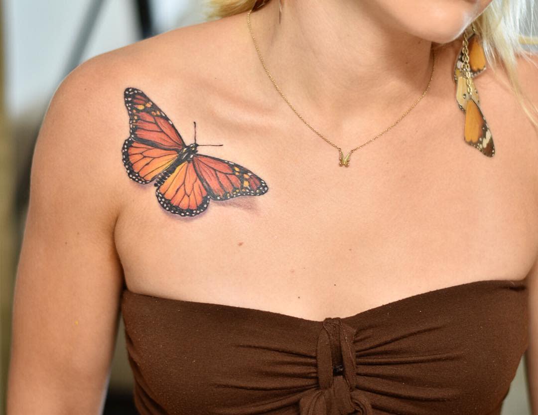 A monarch butterfly tattoo graces a woman's shoulder
