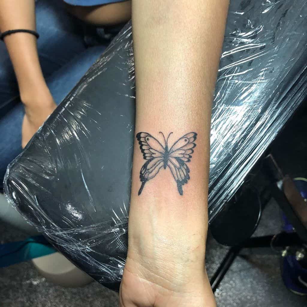 Tattoo of a black monarch butterfly on a wrist