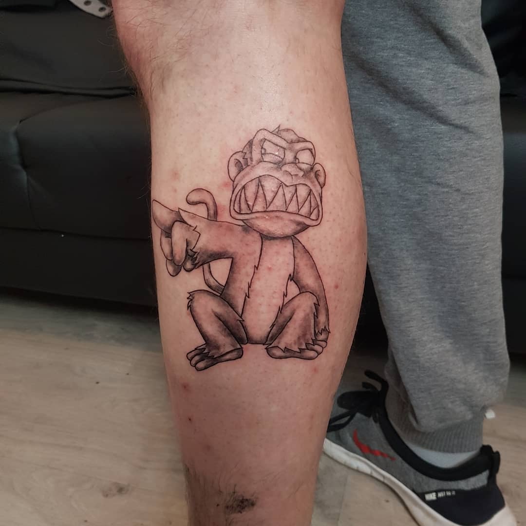 Tattoo of an angry, pointing cartoon monkey on the back of a calf