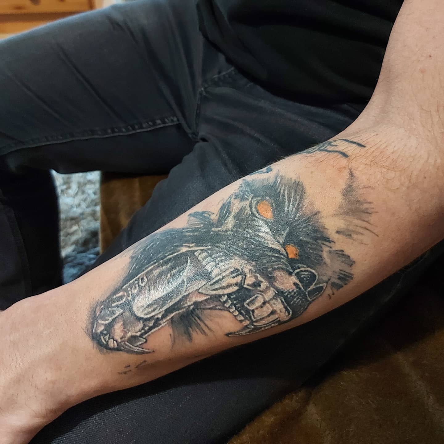 Forearm tattoo of a snarling gorilla with glowing eyes and sharp teeth