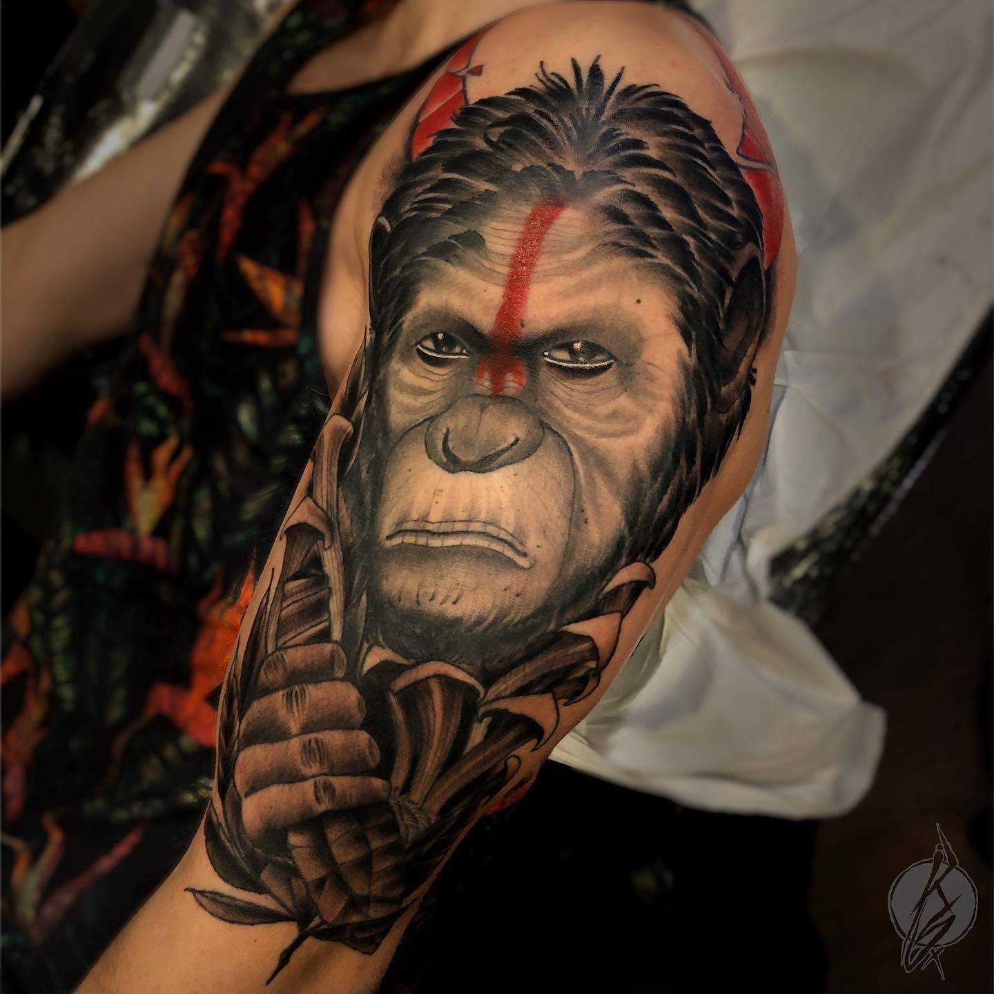 Tattoo of a chimpanzee with war paint on the upper arm