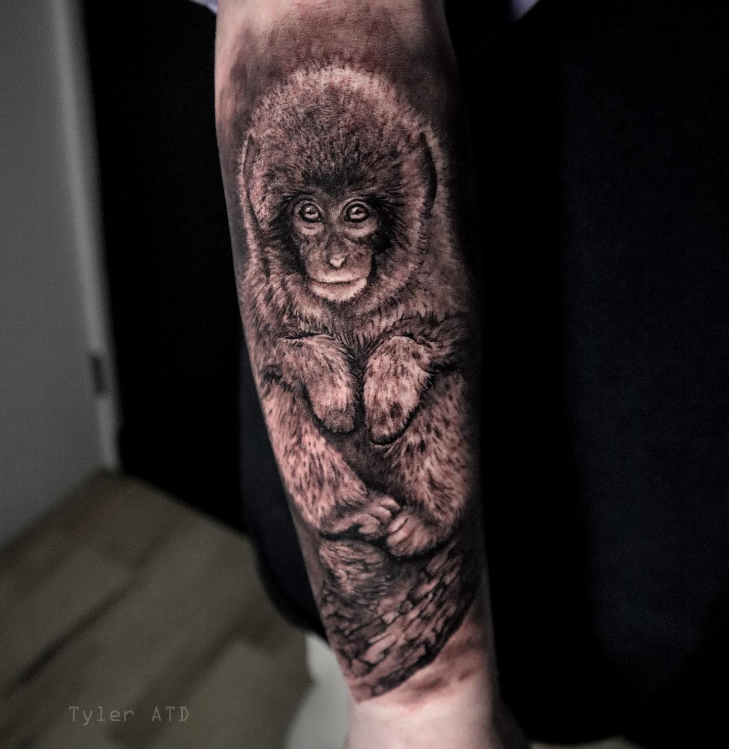 Realistic tattoo of a baby monkey on an arm