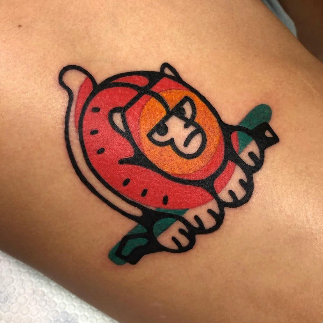Colorful stylized monkey tattoo featuring bold lines and geometric shapes on skin