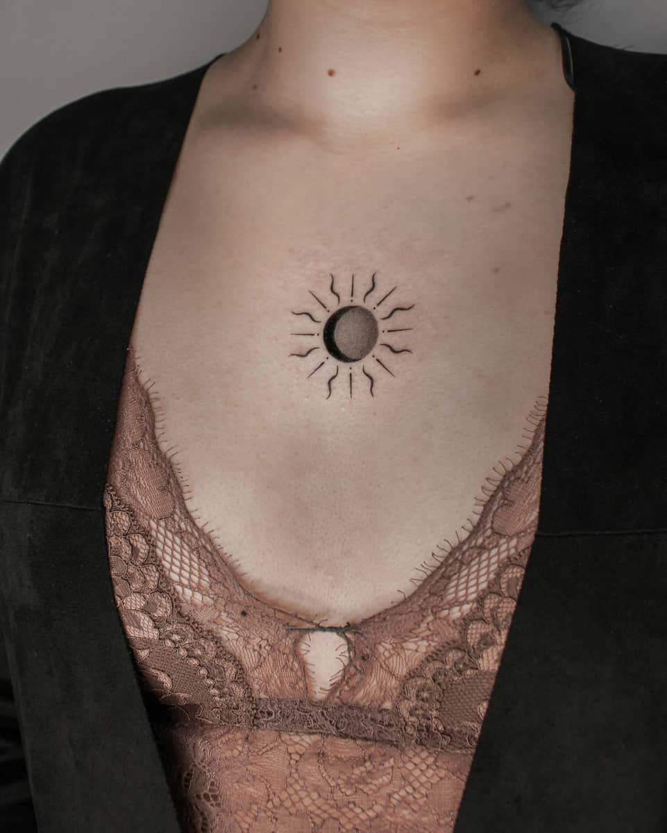 Individual with a sun and moon tattoo on their chest