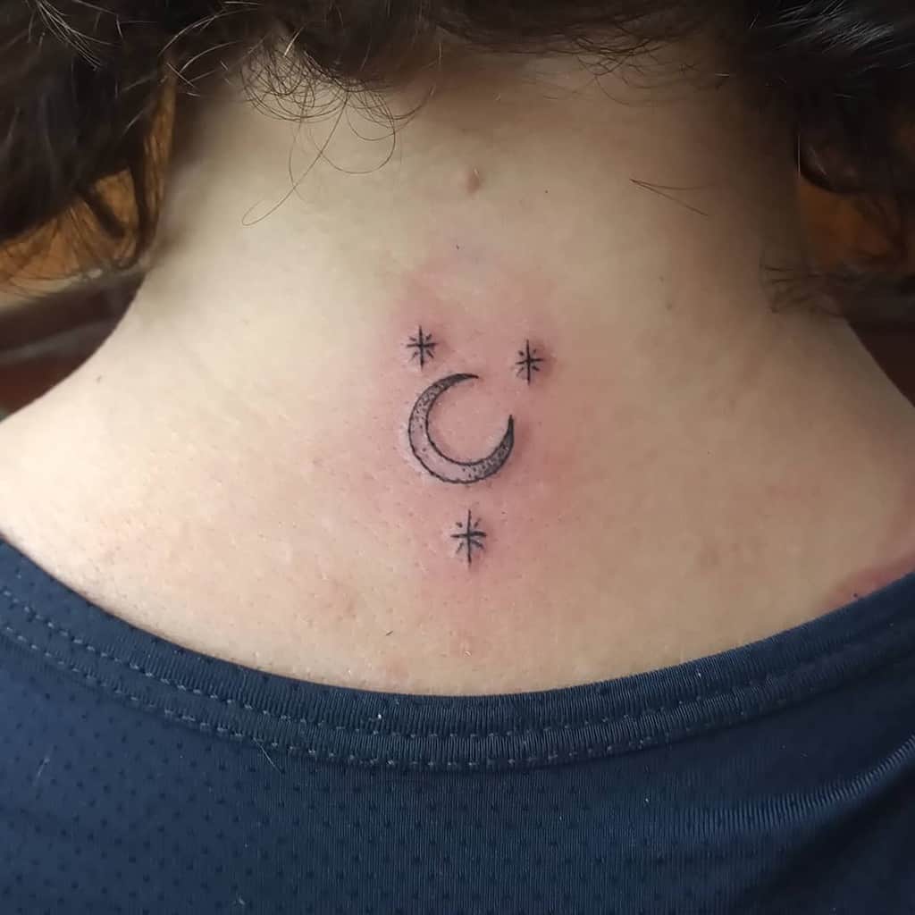A crescent moon tattoo with four stars on the back of the neck