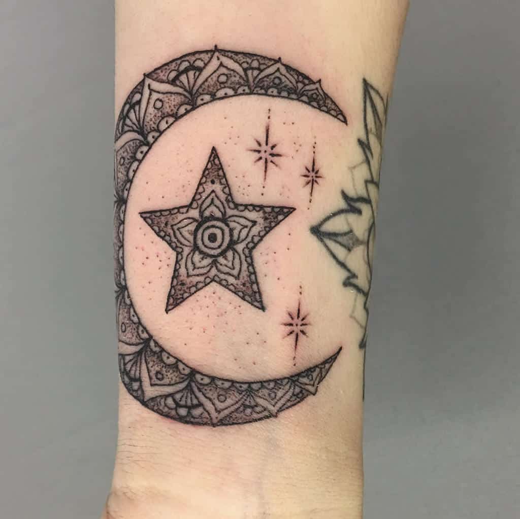 Intricate crescent moon and star tattoo with detailed designs and decorative shooting stars