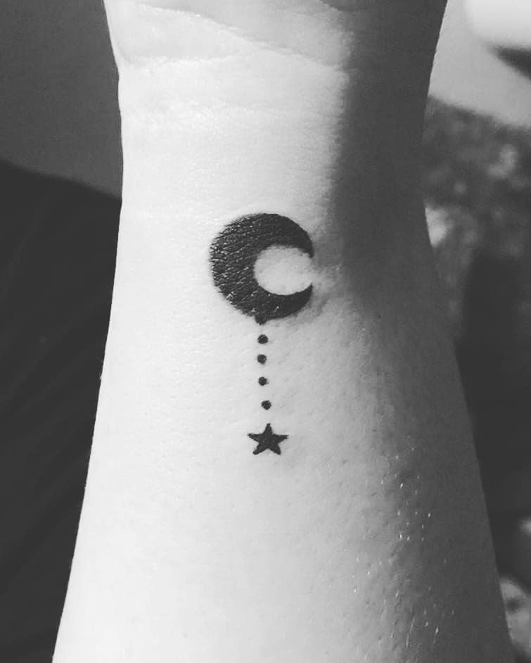Black crescent moon and stars tattoo with dotted line on forearm