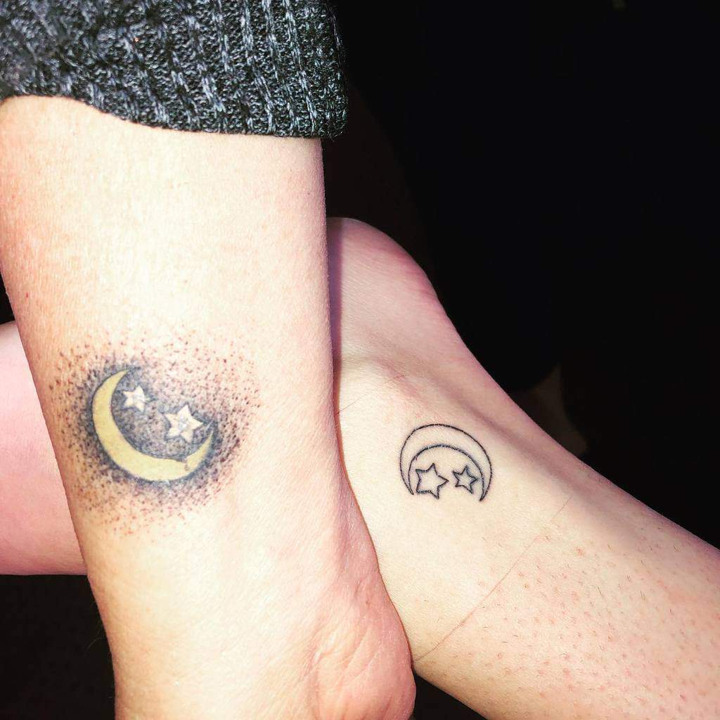 Two crescent moon tattoos with stars, one shaded and the other outlined, on forearms