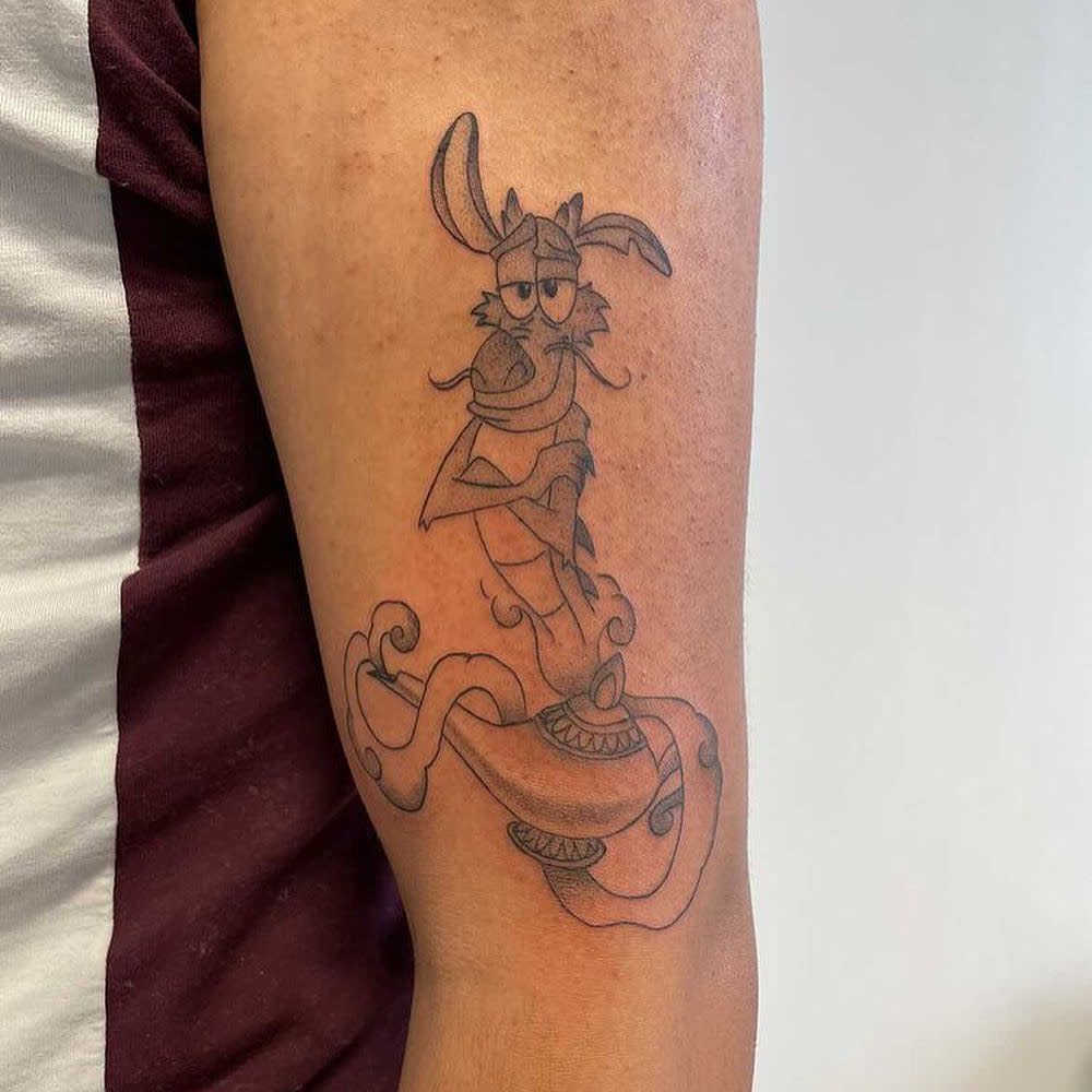 Tattoo of Mushu the dragon coming out of a lamp on an upper arm