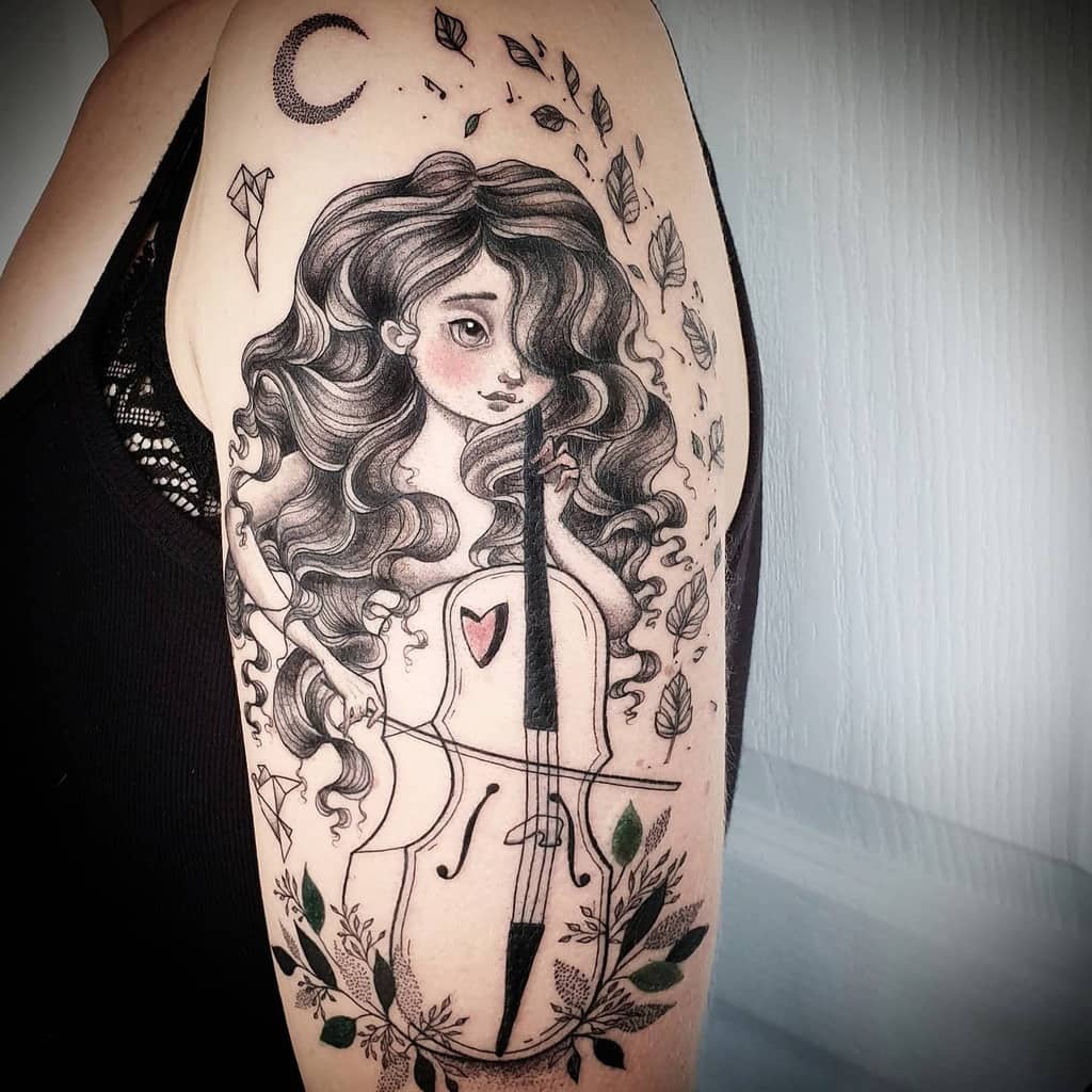 Tattoo of a woman playing a cello, surrounded by leaves and a crescent moon, on an upper arm