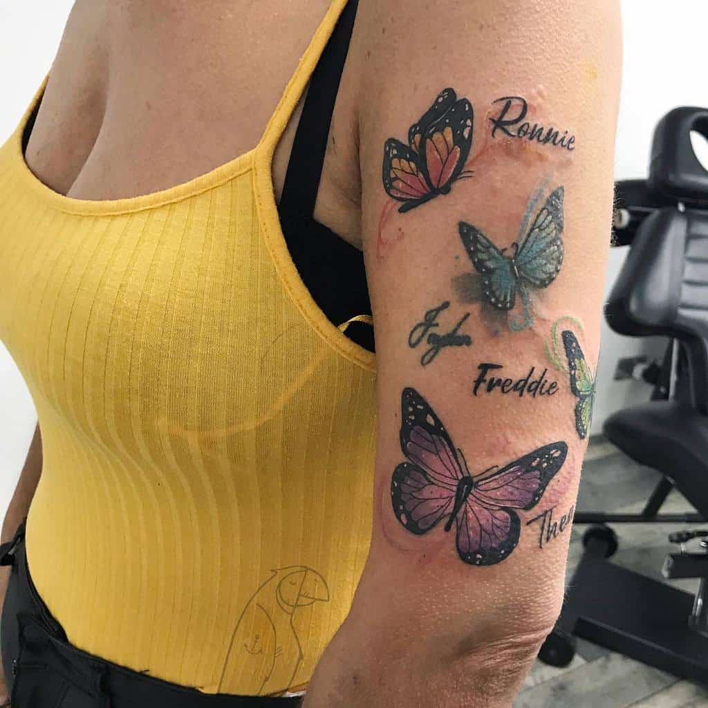A woman with butterfly tattoos on their arm, each labeled with a different name