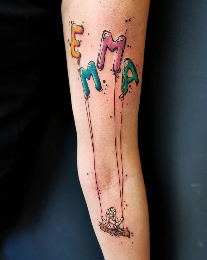 Tattoo of balloons spelling "EMMA" with a child on a swing, held by strings from the balloons