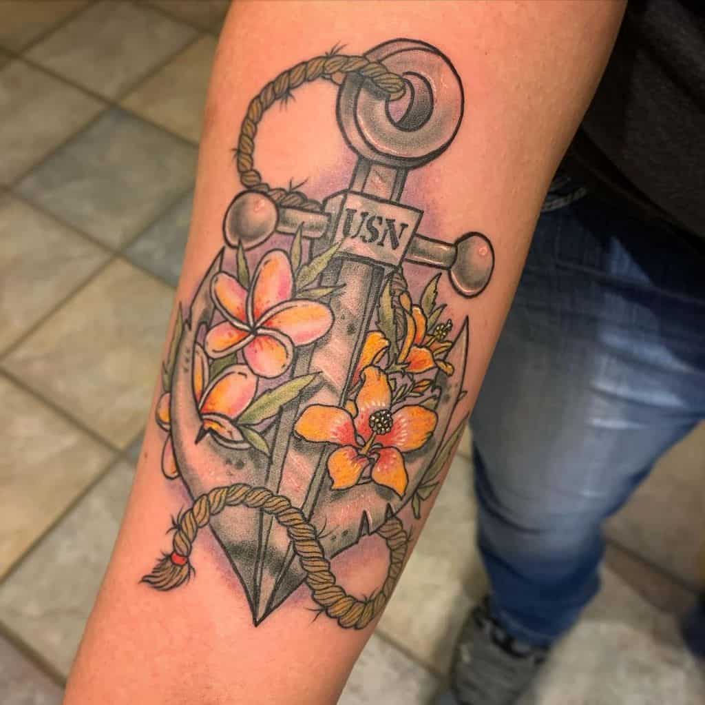 Tattoo of a navy anchor entwined with flowers and a rope, featuring the letters "USN"