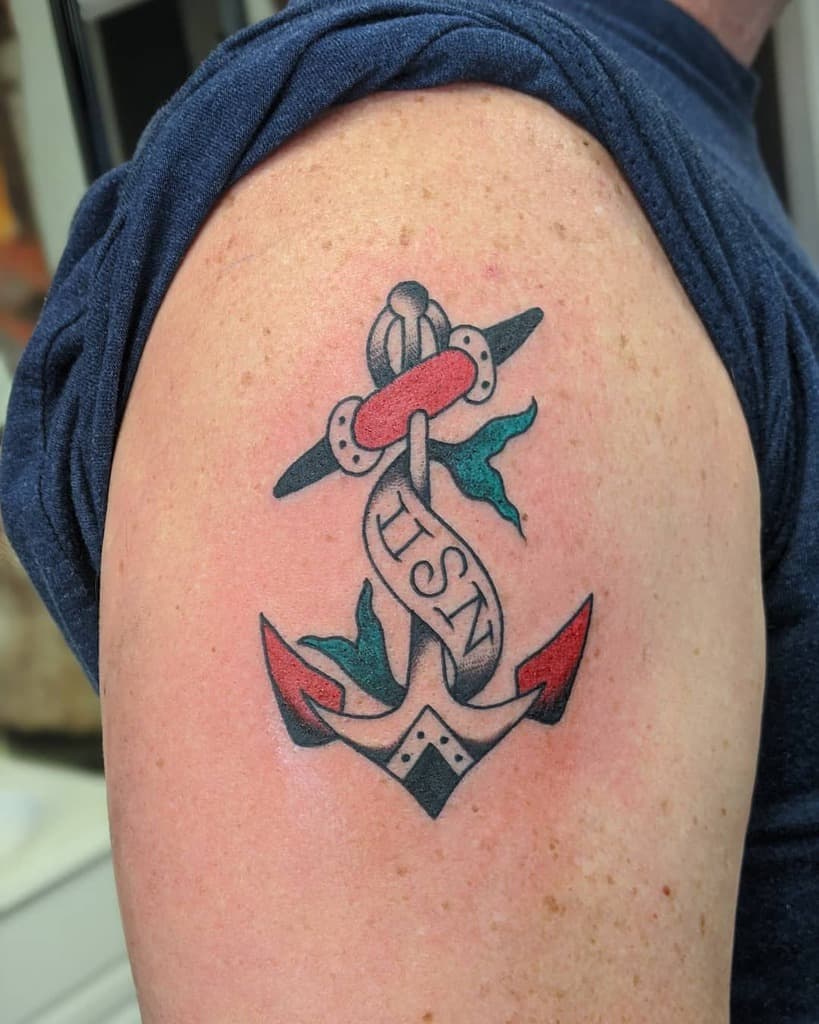 Anchor tattoo with "USN" banner on a person's upper arm