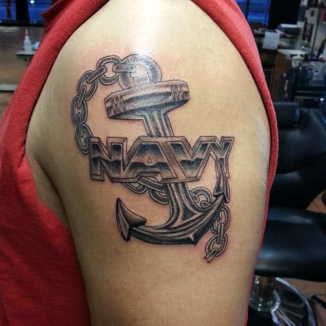 A tattoo of an anchor and chain with the word "NAVY" on an upper arm representing strength and commitment