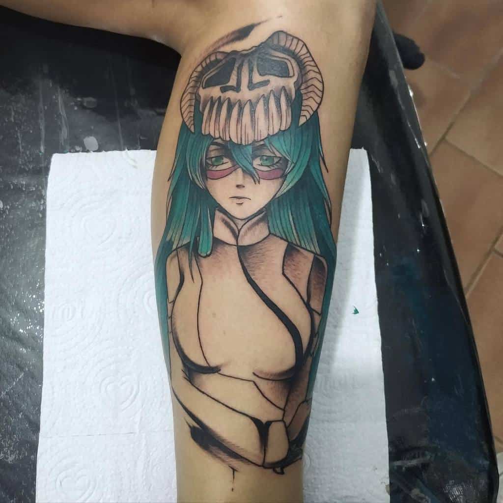 Colorful tattoo of Nelliel Tu Odelschwanck from Bleach, featuring her teal hair, ram skull Hollow mask, red facial markings, and detailed shading