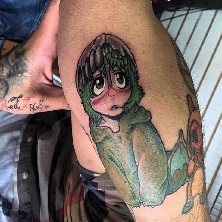 Colorful tattoo of Nelliel Tu Odelschwanck from Bleach in her child form, featuring large expressive eyes, green hair, red facial markings, and a broken mask piece