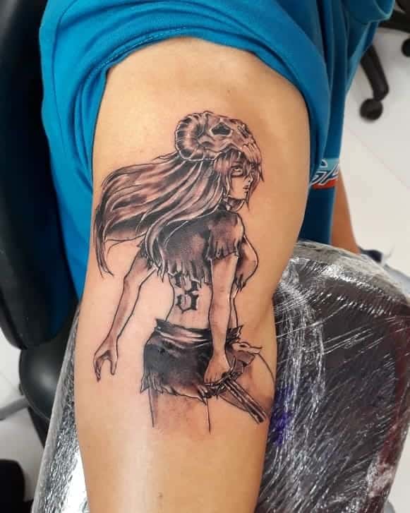 Black and grey tattoo of Nelliel Tu Odelschwanck from Bleach, featuring her long flowing hair, ram skull Hollow mask, and Espada number 3 marking on her back