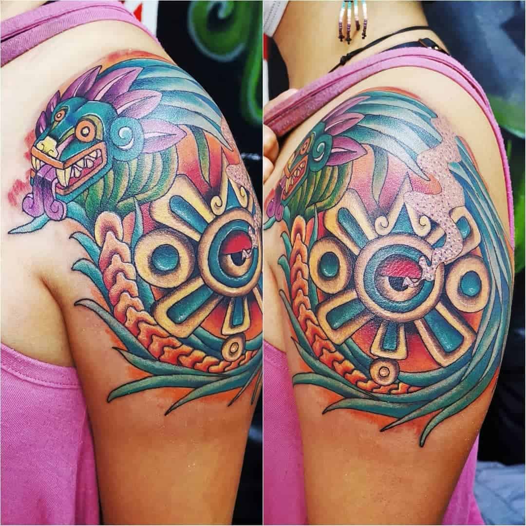 Vibrant neo-traditional Quetzalcoatl tattoo on the shoulder, featuring bold colors and intricate Aztec-inspired designs