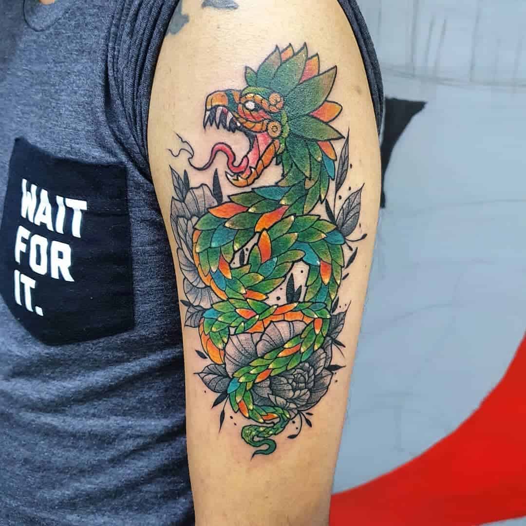 Neo-traditional Quetzalcoatl tattoo with vibrant green and orange feathers, bold snake-like form