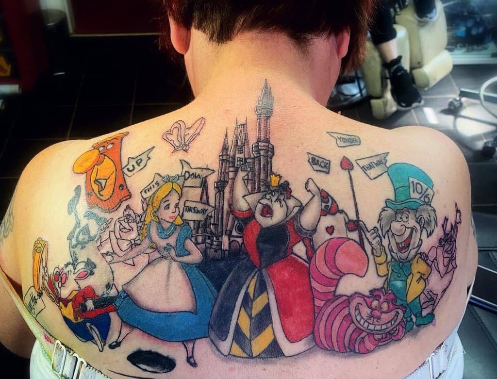 Large, colorful tattoo, featuring characters from Alice in Wonderland, including Alice, Cheshire Cat, Mad Hatter, Queen of Hearts, White Rabbit, door, red queen's guards, signs, hole, butterfly, and castle