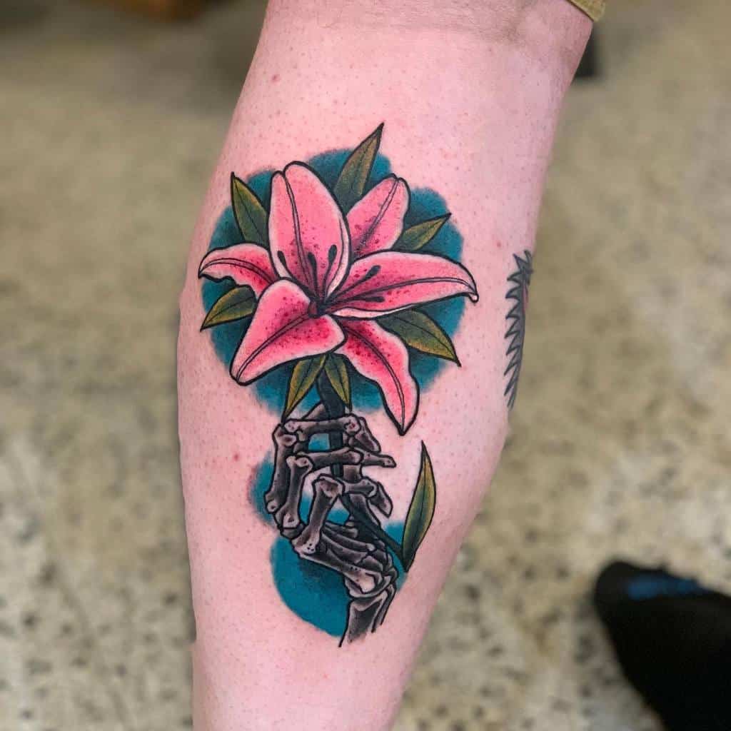 Bold tattoo of a pink lily held by a skeletal hand against a blue background, symbolizing the contrast between life, death, and beauty