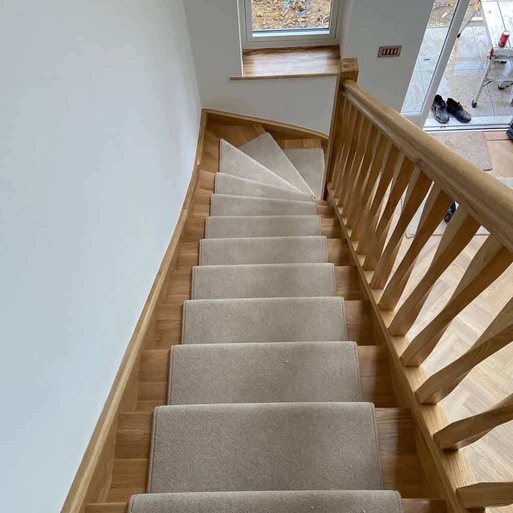 wooden staircase with neutral stair runner