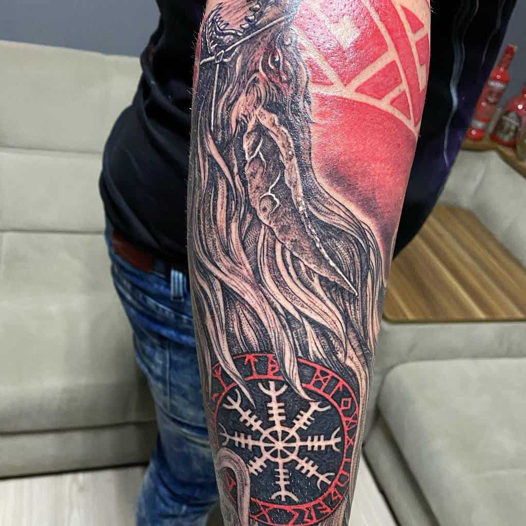 A detailed tattoo featuring a wolf's head with flowing mane, combined with the Vegvisir symbol and red accents in the background