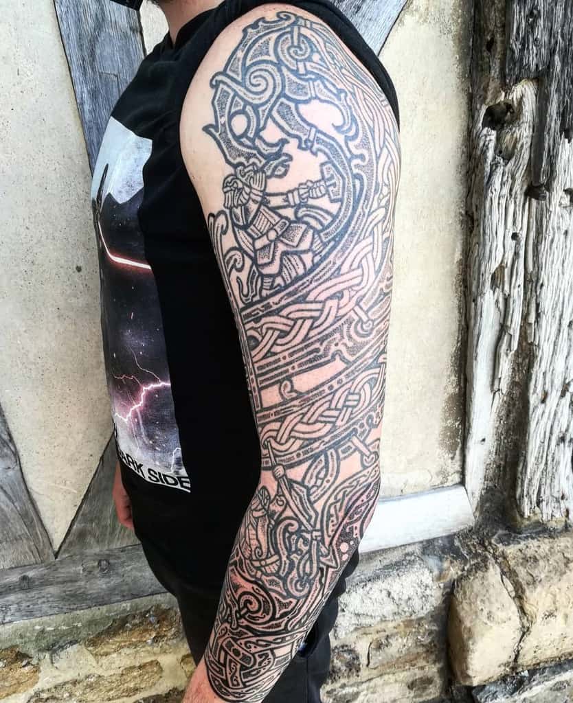 Arm with an intricately designed Celtic knot sleeve tattoo, featuring detailed twists and mythical elements