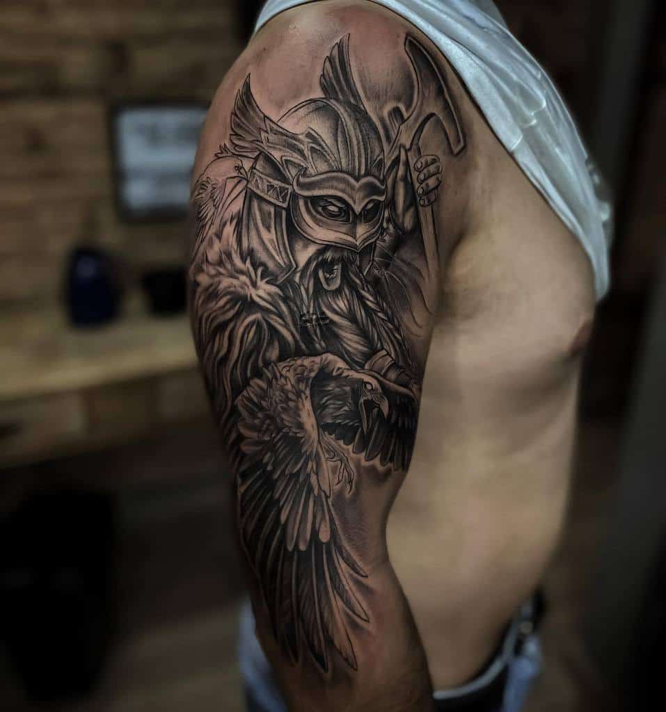 A Nordic half-sleeve tattoo featuring a Viking warrior with a winged helmet, holding an axe, accompanied by a detailed raven in flight