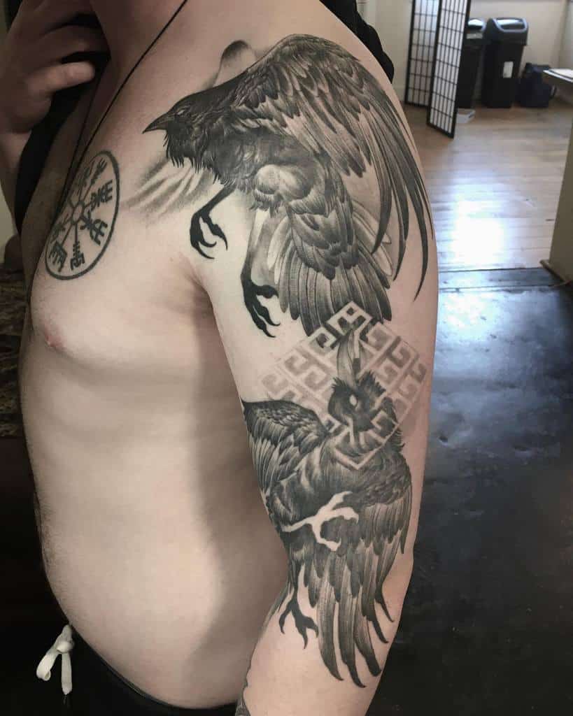 A Nordic half-sleeve tattoo featuring two ravens in flight, intricate knotwork, and the Vegvisir symbol on the chest