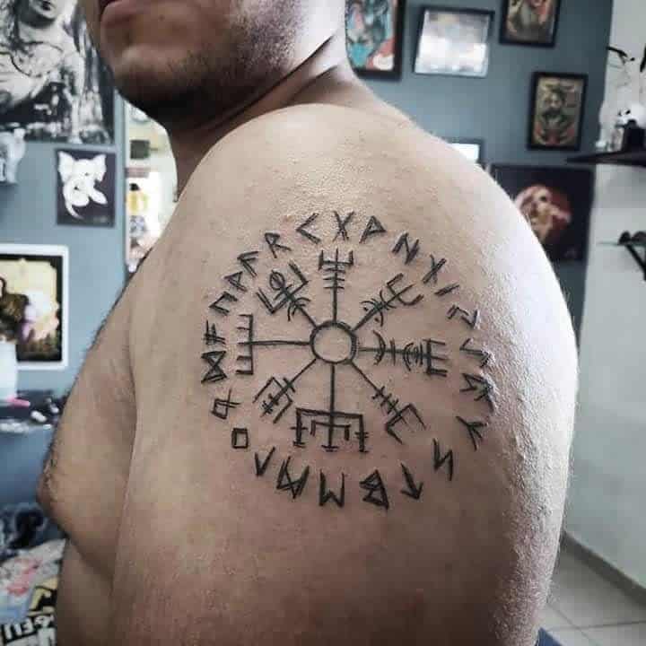 Nordic shoulder tattoo featuring the Vegvisir symbol, surrounded by runic inscriptions, symbolizing guidance and protection
