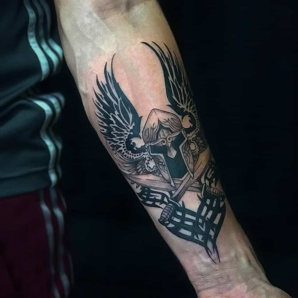 Nordic-inspired Viking forearm tattoo featuring a winged helmet and sword, symbolizing strength and warrior spirit