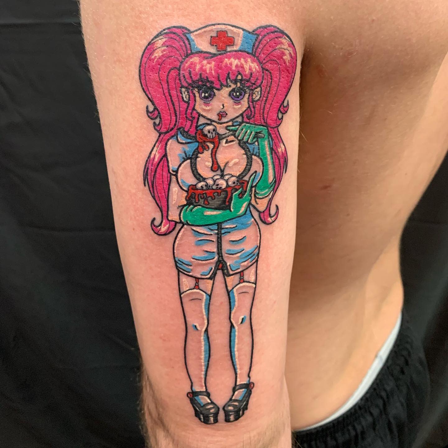 Tattoo of an anime-style nurse with pink hair on an upper arm