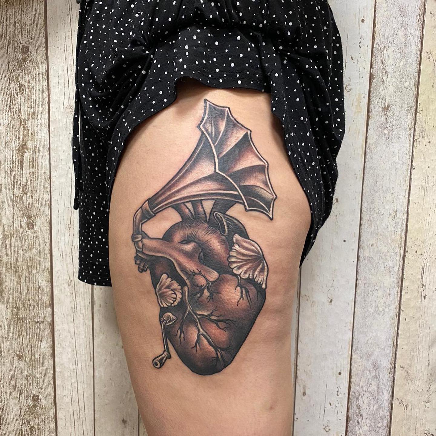 Tattoo of a heart and gramophone on a thigh