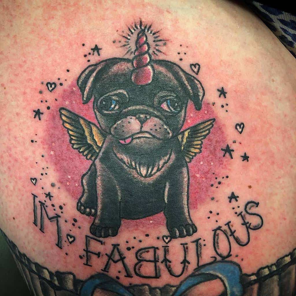 Tattoo of a black pug with a unicorn horn and golden wings, surrounded by stars and hearts with red background, with "I'm Fabulous" written below
