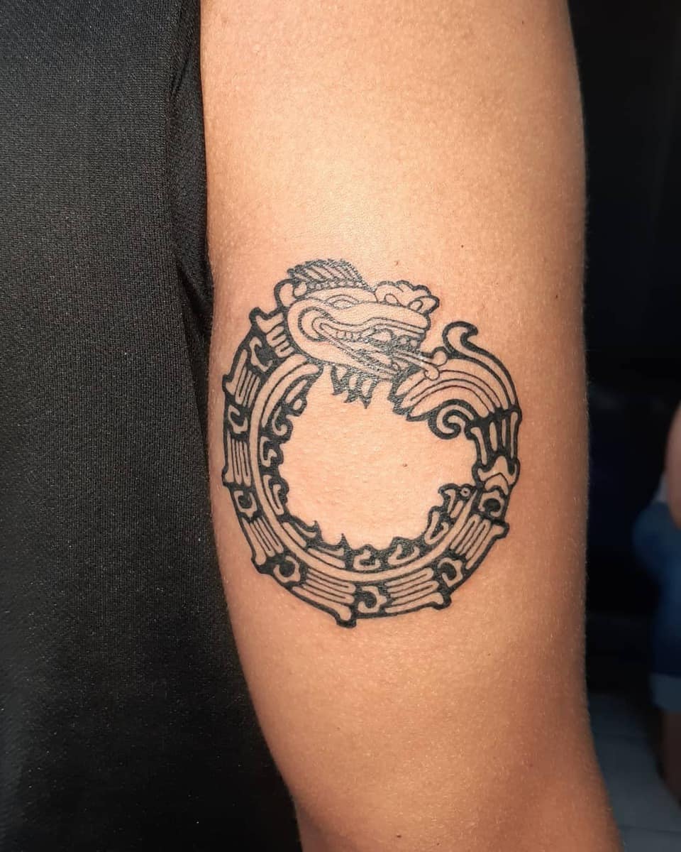 Minimalist black Ouroboros Quetzalcoatl tattoo with circular design, symbolizing infinity